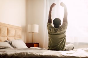 Man stretching stiff back in the morning due to ankylosing spondylitis